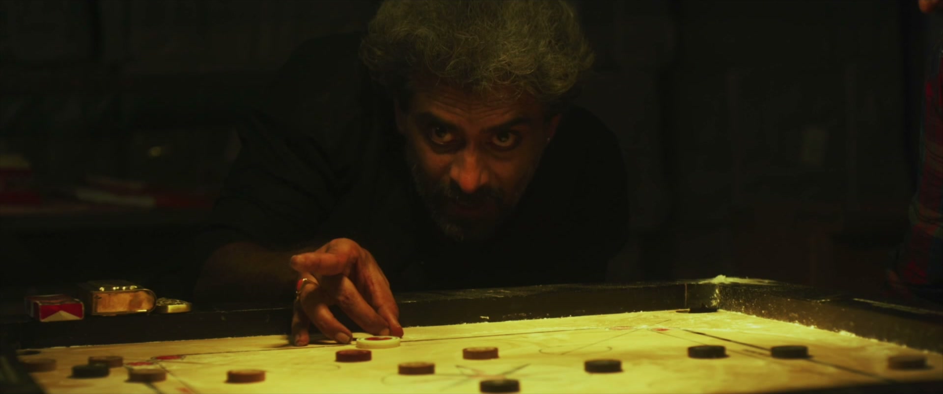 Hands over a lit carrom board